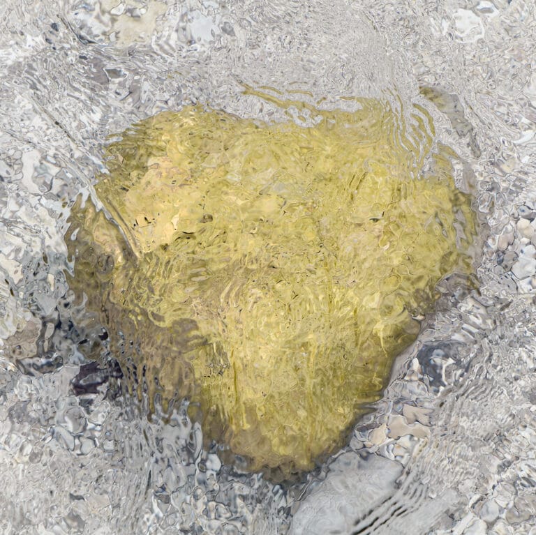 heart shaped stone shimmering through the water surface