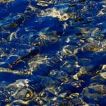 structures and patterns on water surface, colored in blue and gold, looking like Lapislazuli