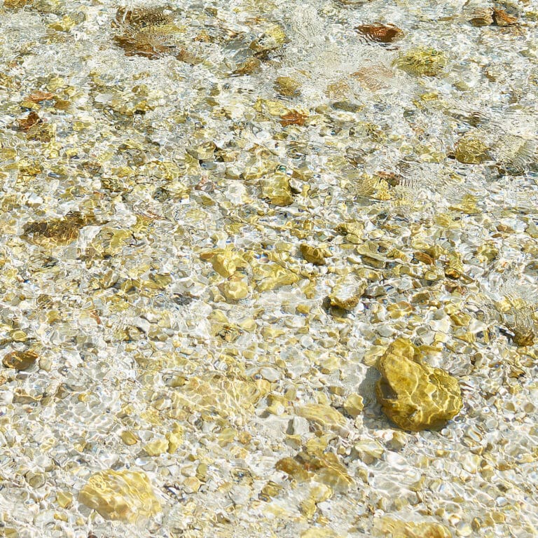 stones and pebbles in water, shimmering like gold nuggets