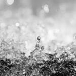 fine art photography of splashing water drops looking like the rising moon Titan