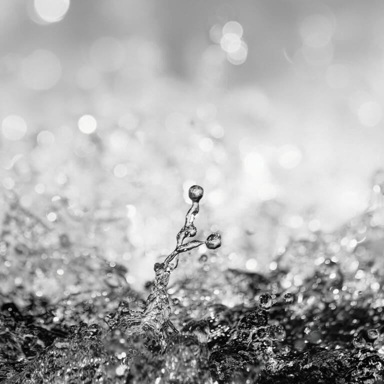 fine art photography of splashing water drops looking like the rising moon Titan